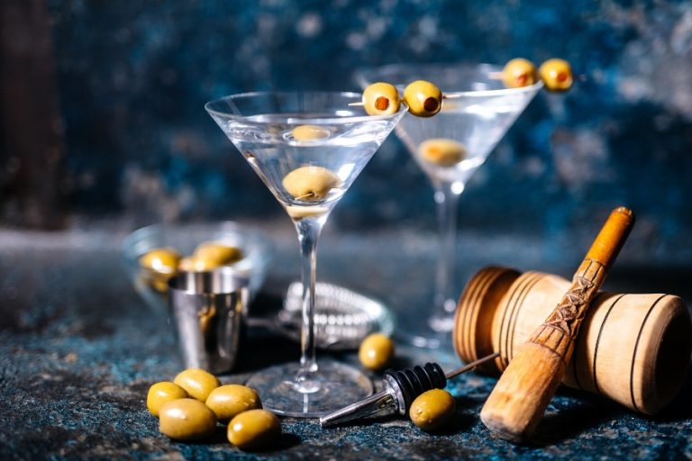 Glasses of dirty martini with olves and bowl of olives