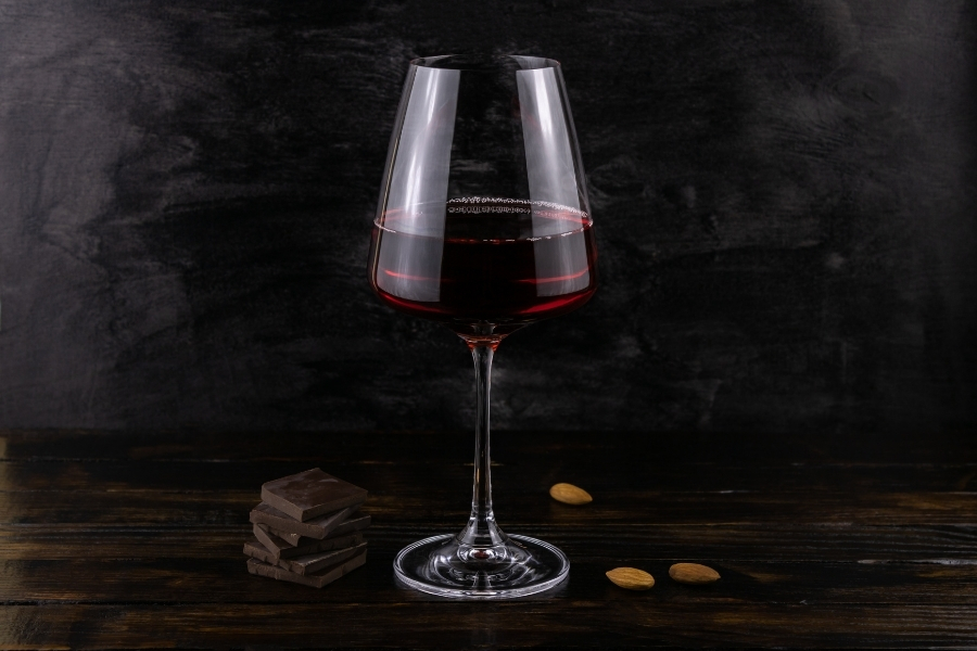 A glass of dark red wine with dark chocolate