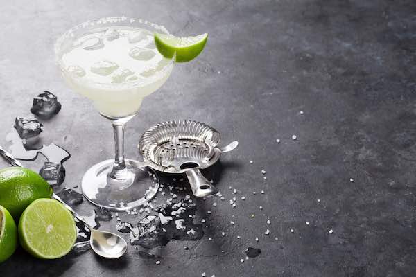 classic marfarita cocktail with slice of lime on grey table