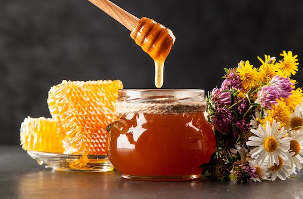 Honey jar and dipper with leaking honey